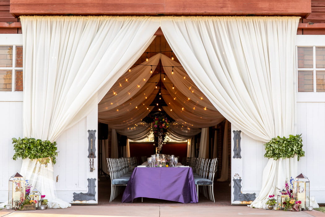 Sheer ivory draping in a cabana style on the barn doors and ceiling draping. Draping by: Draping by Kim