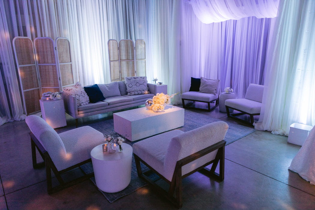 Flying Caballos Barn ivory draping around the walls with blue and purple up lighting. Draping and lighting by: Draping by Kim and photography by Mooncrest Media