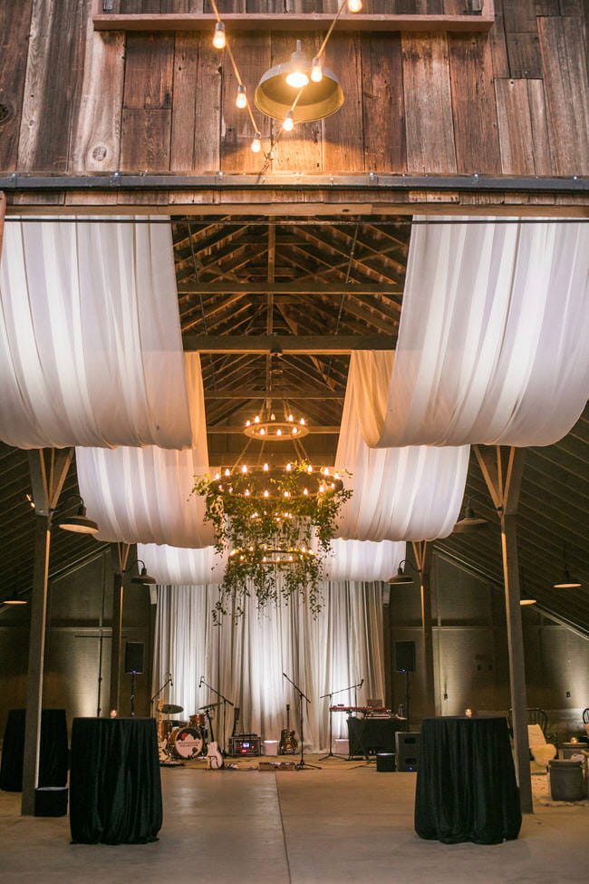 Sheer ivory draping in a pillow style in a barn. Draping by: Draping by Kim